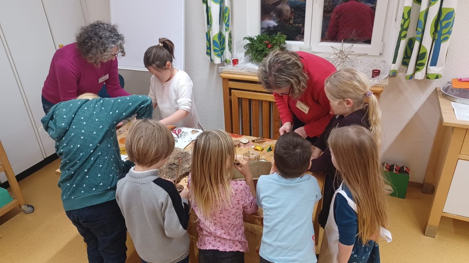 Kinder stehen um einen Basteltisch