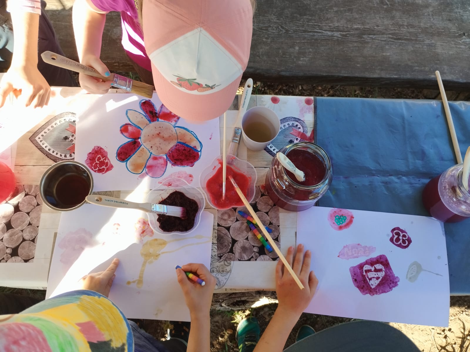 Bunte Farbtöpfe mit Pinseln und Kinderhänden
